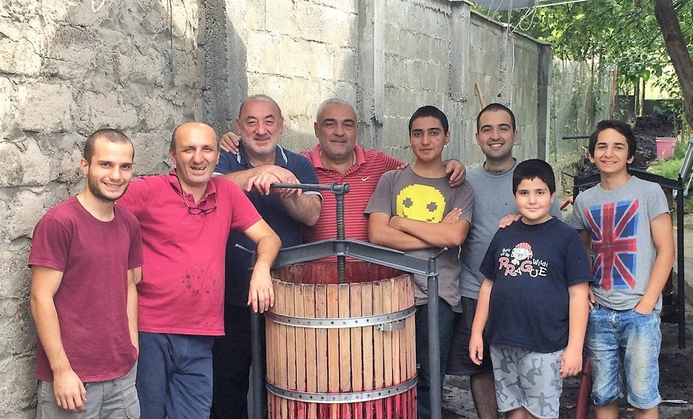 Friends and family standing at a winepress